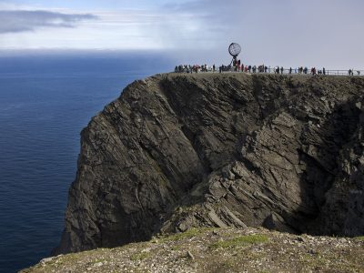 Tourists and a sculpture on a cliff, Honningsvag Port, Honningsvag, Mageroya Island, Nordkapp, Finnmark County, Norway